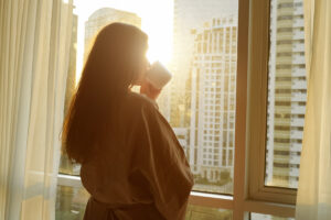 Woman enjoying a peaceful morning after better sleep after 50 with a healthy bedtime routine and restful sleep habits.