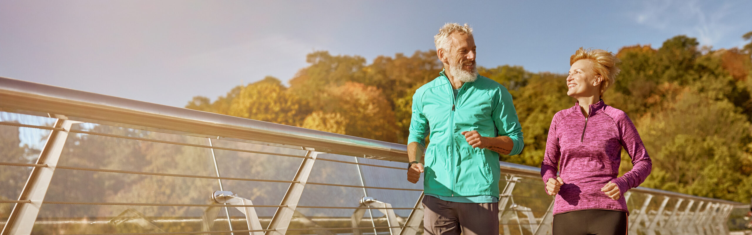 Active mature couple outdoors in fall as part of a healthy daily routine for immune health